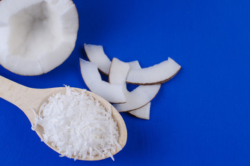 Natural coconut milk, coconut shavings, coconut chips on a blue background. The concept of healthy food.
