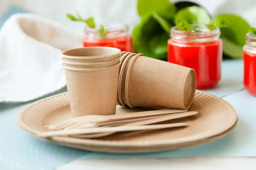disposable eco tableware on a light background of paper cardboard spoon fork knife