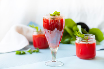 Crystal bakery with a drink, homemade cold juice with mint with fresh berries on a light background. Selective focus.