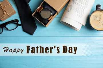 Flat lay composition with male accessories and phrase HAPPY FATHER'S DAY on light blue wooden table