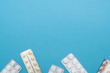 top view of pills in blister packs on blue background
