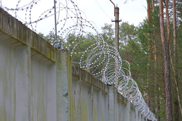 Gray concrete fence and barbed wire