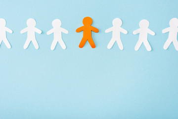 Top view of orange decorative man among white on blue background