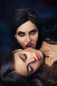 fantasy portrait face sexy evil vampire woman bites eating drinks young beauty lady. death blonde girl. Horror night halloween. Holiday scary bloody makeup red lips sharp teeth fangs in open mouth