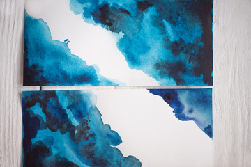 Top view of paper with Japanese painting with blue watercolor on wooden background