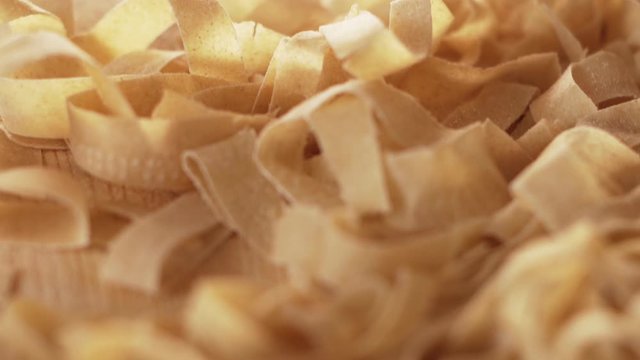 Macro close up tracking view of fresh home made tagliatelle pasta just rolled and cut with bokeh effect