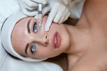 Obraz na płótnie Canvas Face Treatment. Anti Aging Beauty Injection In Forehead. Skincare Rejuvenation Procedure In Cosmetic Clinic. Beautician Hands In Gloves With Syringe.