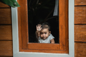 cute asian baby peeking from a window