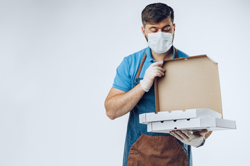 Obraz na płótnie Canvas Pizza delivery man in medical gloves and mask against grey background. Safe service while coronavirus covid-19 outbreak