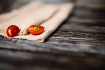 A linen fabric with tomatoes on the wooden background with the place for text
