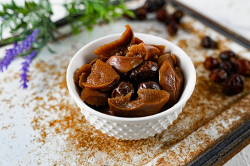 Sweet and soft dried Apple and rose hips prepared for dessert, decorated with a sprig of lavender and dry fruits on an unusual white and rusty metal background