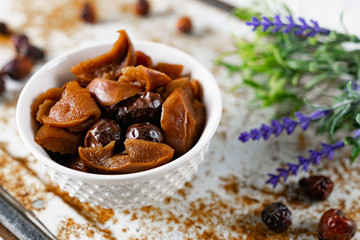 Sweet and soft dried Apple and rose hips prepared for dessert, decorated with a sprig of lavender and dry fruits on an unusual white and rusty metal background