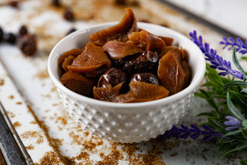Sweet and soft dried Apple and rose hips prepared for dessert, decorated with a sprig of lavender and dry fruits on an unusual white and rusty metal background
