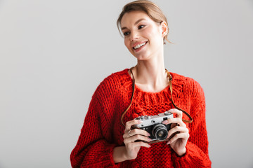 Image of young cheerful woman smiling and using retro camera