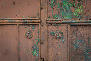 ancient rusty metallic door with a brown peeling paint