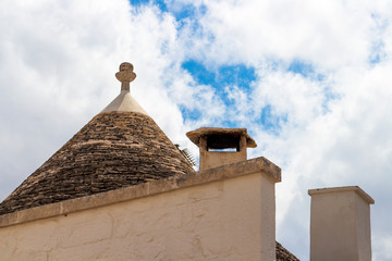 Fototapeta na wymiar Conical roof of an old trullo, traditional Apulian dry stone hut in Alberobello, Apulia Region, Metropolitan City of Bari, Italy against beautiful cloudy summer sky
