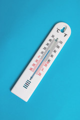 White room thermometer on a blue background