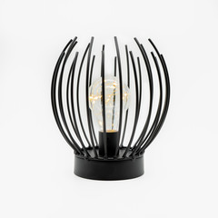 A table lamp with upright metal sticks and an LED light bulb inside, cut out on white background
