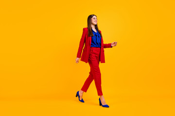 Full body profile photo of attractive self-confident business lady bossy walk office center wear specs red luxury office blazer trousers suit high-heels isolated yellow color background
