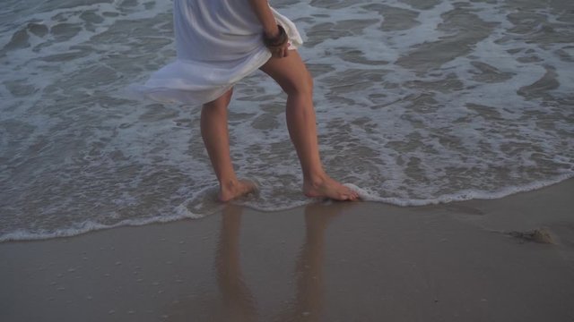 Legs of a playful woman on the shore of the beach