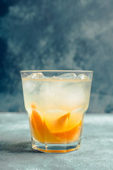 Old fashioned beverage with orange slices on rustic background. Selective focus. Shallow depth of field.
