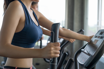 Fototapeta premium Close up of young woman running and exercise on electric treadmill in fitness room.
