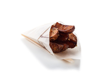 French fries in a gift wrapping on a white background (close)