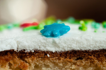 Sweet confectionery star of blue color on a slice of Easter cake close-up. Macro shot.