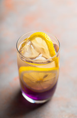 Gin based colorful cocktail with lemon and lavender liqueur on the rustic background. Selective focus. Shallow depth of field.