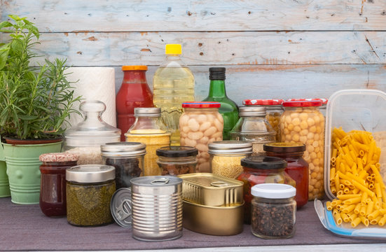 Covid-19 coronavirus infection. Small pantry of food for the period of isolation in quarantine. Several glass jars with cereals, legumes, jams, pasta and rice, canned cans