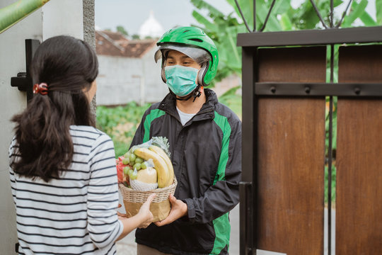 Food Delivery. Delivery Man Wear Face Masks During Delivering Food To People While Staying Home During Corona Virus Pandemic