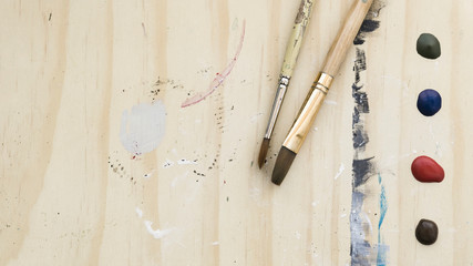 Background of brushes on painted wooden easel with copyspace