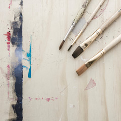 Background of brushes on painted wooden easel with copyspace