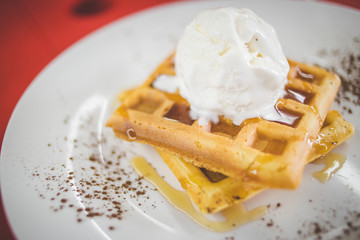 Close up image of a delicious waffle being served as desert in a restaurant
