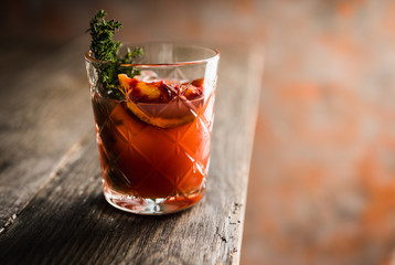 Old-fashioned cocktail with blood oranges and thyme on the rustic background. Selective focus. Shallow depth of field.