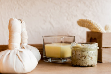 selective focus of herbal bags near clay mask in jar and candle