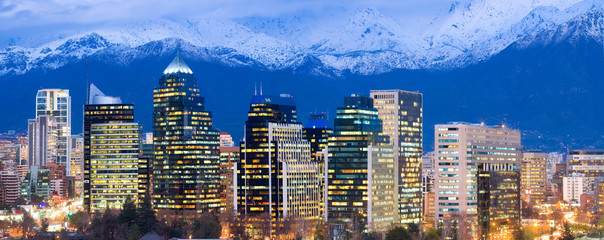Skyline of modern office buildings at Las Condes and Providencia districts with snowed Andes mountain Range in the back, Santiago de Chile, South America