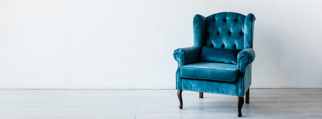 panoramic crop of blue and comfortable armchair near white wall in living room