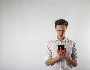 Young man in white using smartphone.