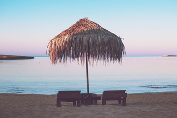Photo of vacant beach shack made up of dried palm leaves on a deserted beach of island during...