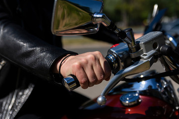 Biker riding on a motorcycle. View of a hand on handlebar giving gas