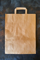 Blank eco brown paper bag on dark background. Craft grocery bag. Mockup. Copy space