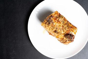 A large piece of baked meat on a white plate