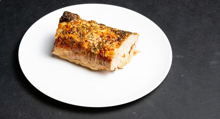 A large piece of baked meat on a white plate