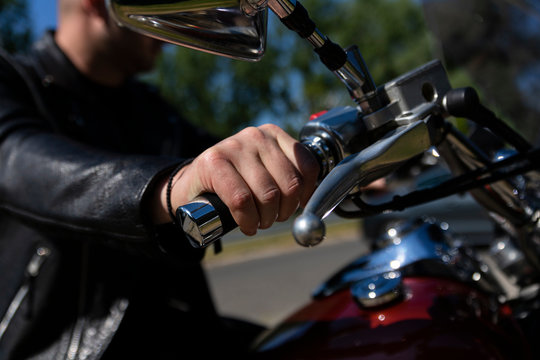 Biker riding on a motorcycle. View of a hand on handlebar giving gas