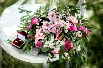 Partial view of florist holding bouquet of fresh flowers on wooden surface