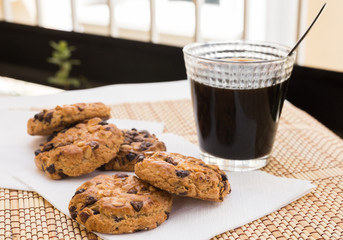 cookies with chocolate and hazelnuts and coffee are on table