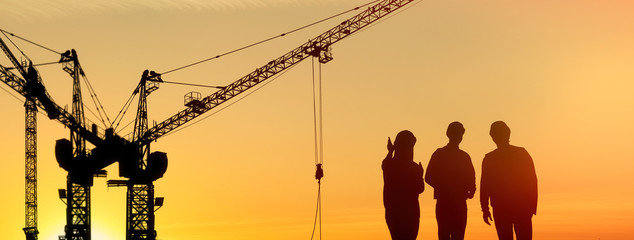 Silhouettes of engineers near construction site at sunrise. Banner design