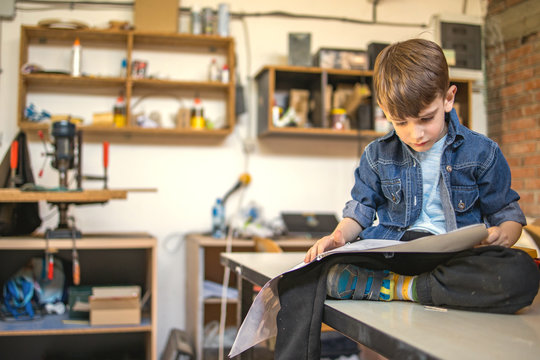Cute Boy Reading Instructions How To Make Birdhouse	