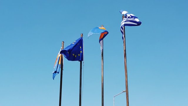 European and Greek flags waving on a pole on the port of Thessaloniki in Greece